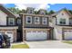 Inviting townhome displaying a two-car garage and charming curb appeal with well-maintained landscaping at 7805 Rock Rose Ln, Fairburn, GA 30213