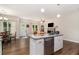 Open-concept living room with kitchen island, fireplace and hardwood floors at 7805 Rock Rose Ln, Fairburn, GA 30213