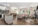 Open-concept living space with hardwood floors, kitchen island, dining, and cozy seating area at 7805 Rock Rose Ln, Fairburn, GA 30213