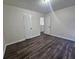 A clean bedroom with light-colored walls and wood flooring, illuminated by natural light from a window at 1857 Oak Hill Springs Blvd, Lithonia, GA 30058