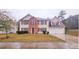 Traditional two-story home with a two-car garage, symmetrical design and landscaped front yard at 1857 Oak Hill Springs Blvd, Lithonia, GA 30058