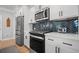 Bright kitchen features white cabinetry, stainless steel appliances, and herringbone backsplash at 1914 Carovel Way, Kennesaw, GA 30144