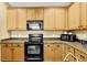 This kitchen features wooden cabinets, granite countertops and black appliances at 3461 Dianthus Ln, Lawrenceville, GA 30044