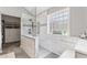 Bright bathroom featuring glass enclosed shower, patterned tile accent wall and a glass block window at 406 Genevieve Dr, Canton, GA 30114