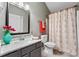 Well-lit bathroom featuring a modern vanity with a decorative mirror and a floral shower curtain at 406 Genevieve Dr, Canton, GA 30114