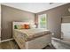 Comfortable bedroom with neutral walls, one window, and a full size bed with patterned bedding at 406 Genevieve Dr, Canton, GA 30114