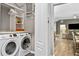 Functional laundry room featuring modern washer and dryer, shelving for storage and access to living area at 406 Genevieve Dr, Canton, GA 30114