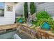Water feature with statue and lush planters adjacent to patio and home at 406 Genevieve Dr, Canton, GA 30114