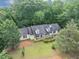 Aerial view of a well maintained home with lush green grass and surrounded by tall trees at 1050 Birdseye Vw, Locust Grove, GA 30248