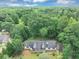 Beautiful aerial view showcasing the home's roofline and surrounded by lush greenery, set against a blue sky at 1050 Birdseye Vw, Locust Grove, GA 30248