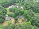 Stunning aerial view of the property with a pond, home, and verdant trees, showcasing its natural beauty and tranquility at 1050 Birdseye Vw, Locust Grove, GA 30248