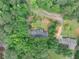 A charming home in a leafy area, surrounded by mature trees, with a long driveway and landscaping at 1050 Birdseye Vw, Locust Grove, GA 30248