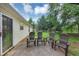 Backyard with 4 chairs and concrete patio, sliding glass doors, and luscious green surroundings at 1050 Birdseye Vw, Locust Grove, GA 30248