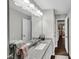 Bright bathroom featuring granite countertops, a large mirror, and dark wood floors at 1050 Birdseye Vw, Locust Grove, GA 30248