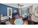 Bedroom featuring blue accent wall, dark wood crib, changing table, and ceiling fan at 1050 Birdseye Vw, Locust Grove, GA 30248