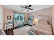 Bedroom featuring a large window, ceiling fan, pink walls, and wood flooring at 1050 Birdseye Vw, Locust Grove, GA 30248