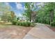 Long driveway leading up to a single-Gathering home, surrounded by mature trees and greenery at 1050 Birdseye Vw, Locust Grove, GA 30248