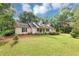 Traditional single-Gathering home with a large front yard, mature trees, and manicured landscaping at 1050 Birdseye Vw, Locust Grove, GA 30248