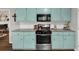 Well-lit kitchen featuring stainless steel appliances, granite countertops, and light blue cabinets at 1050 Birdseye Vw, Locust Grove, GA 30248