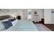 Relaxing main bedroom with soft blue linens, plush pillows, dark floors, and plenty of natural light at 1050 Birdseye Vw, Locust Grove, GA 30248