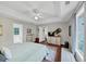 Bright main bedroom features tray ceiling, dark floors, a ceiling fan, and plenty of natural light at 1050 Birdseye Vw, Locust Grove, GA 30248