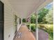 View of the front porch, featuring classic columns, a welcome mat, and a glimpse of the surrounding greenery at 1050 Birdseye Vw, Locust Grove, GA 30248