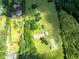Drone shot showcases the property, including house, fields, garden, and treeline at 1502 Campground Rd, Mcdonough, GA 30252