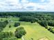 Aerial view of the property surrounded by a vast landscape of lush green fields and trees at 1502 Campground Rd, Mcdonough, GA 30252