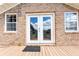 Inviting back porch with brick exterior, double doors, and a 'Welcome' mat at 1502 Campground Rd, Mcdonough, GA 30252