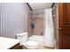 Small bathroom featuring blue striped wallpaper, tub and toilet at 1502 Campground Rd, Mcdonough, GA 30252