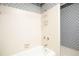 Bathroom with wallpaper, white tile surround tub and brass fixtures at 1502 Campground Rd, Mcdonough, GA 30252