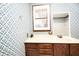 Bathroom featuring printed wallpaper, wood cabinets and window with shutters at 1502 Campground Rd, Mcdonough, GA 30252
