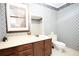 Bathroom featuring printed wallpaper, wood cabinets, window with shutters and toilet at 1502 Campground Rd, Mcdonough, GA 30252