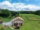 Front exterior of a raised home with a large yard, long driveway, and additional outbuildings visible at 1502 Campground Rd, Mcdonough, GA 30252
