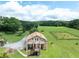 Front exterior of a raised home with a large yard, long driveway, and additional outbuildings visible at 1502 Campground Rd, Mcdonough, GA 30252