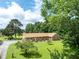 Landscaped brick home with a well-manicured lawn and mature trees at 1502 Campground Rd, Mcdonough, GA 30252