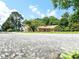 Low-angle, front exterior featuring a brick home with mature trees and manicured lawn, showcasing its curb appeal at 1502 Campground Rd, Mcdonough, GA 30252