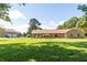 Wide front yard view of a brick home and detached garage; lush green lawn under a sunny sky at 1502 Campground Rd, Mcdonough, GA 30252