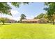Spacious front yard showcasing a lush green lawn and a charming brick home with a detached garage at 1502 Campground Rd, Mcdonough, GA 30252
