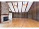 Spacious living room with hardwood flooring, brick fireplace, wood paneling, and high ceilings at 1502 Campground Rd, Mcdonough, GA 30252