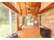 Wood-paneled sunroom featuring a brick floor, and walls of windows offering a view of the outdoor scenery at 1502 Campground Rd, Mcdonough, GA 30252