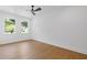 Bright, empty bedroom with hardwood floors, a ceiling fan, and large windows overlooking the yard at 2060 North Avenue Nw, Atlanta, GA 30318