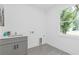 Well-lit laundry room with a gray cabinet, stainless steel sink, and tiled floors at 2060 North Avenue Nw, Atlanta, GA 30318