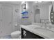 Bathroom with blue floating shelves, toilet, white sink and cabinet, towel rack, mirror, and cabinet lighting at 2683 Tritt Springs Ne Trce, Marietta, GA 30062