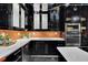 The gourmet kitchen features black cabinetry, stainless steel appliances, and a stylish mosaic backsplash at 2683 Tritt Springs Ne Trce, Marietta, GA 30062