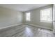 Bedroom featuring hardwood floors and two windows at 6700 Roswell Rd # 21E, Sandy Springs, GA 30328