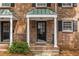 Charming brick townhouse featuring covered entryway with black door and white columns at 6700 Roswell Rd # 21E, Sandy Springs, GA 30328