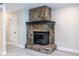 Close-up of the living room fireplace with stone surround and dark mantel at 6700 Roswell Rd # 21E, Sandy Springs, GA 30328