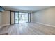 Living room with hardwood floors and sliding glass doors to the sunroom at 6700 Roswell Rd # 21E, Sandy Springs, GA 30328