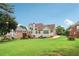 Exterior home with deck, large grassy lawn, mature trees, and professional landscaping at 3223 Thornecreek Dr, Douglasville, GA 30135